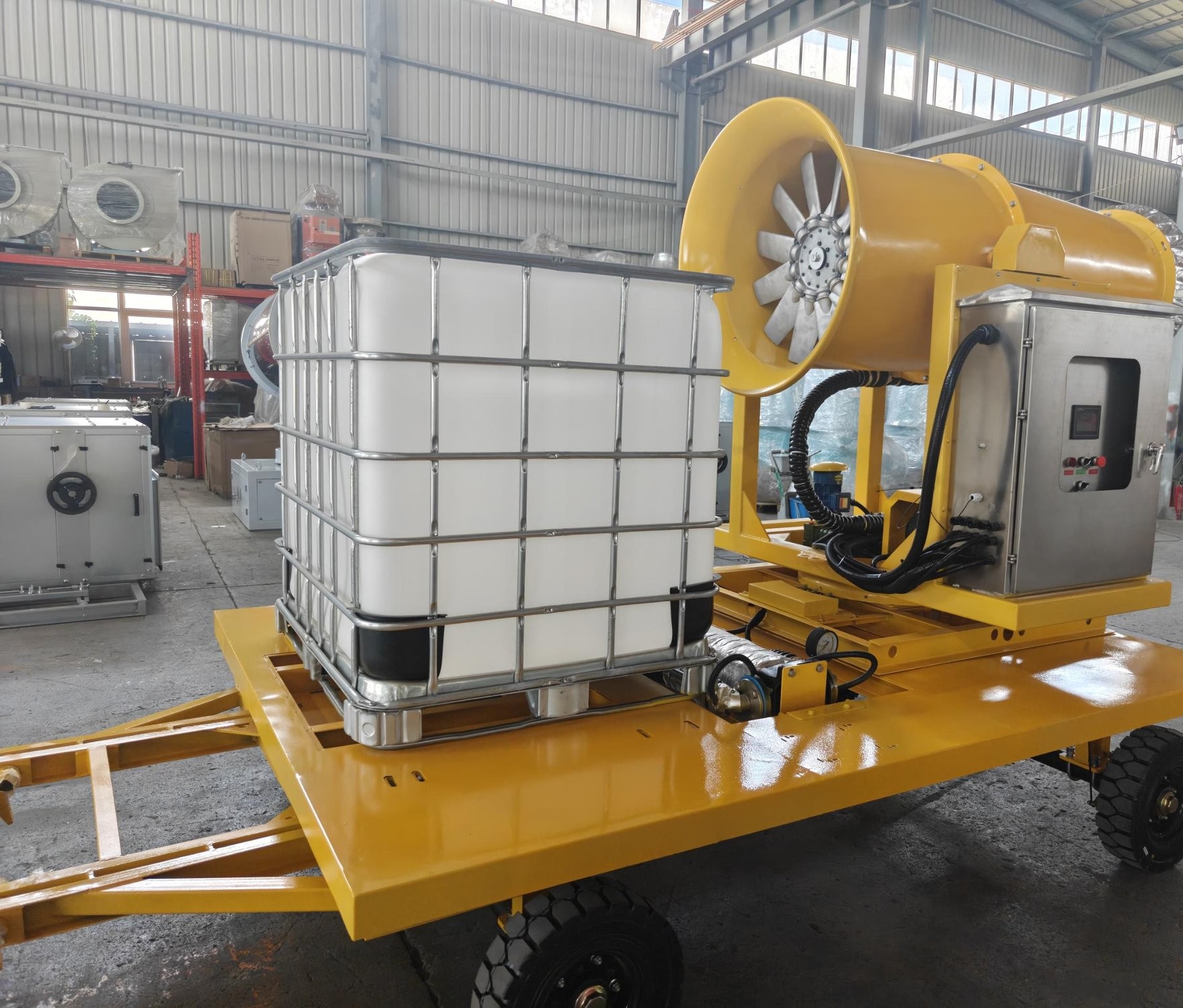 Side view of a mobile fog cannon unit and integrated tank in a workshop