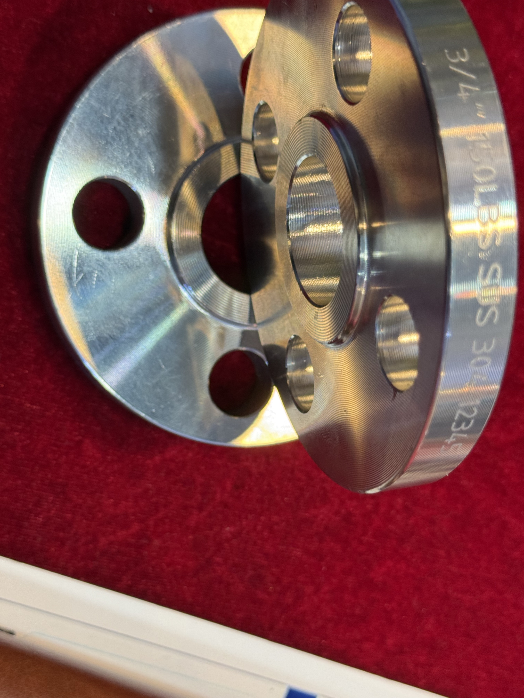 Nahaufnahme von Metallflanschen mit mittigen Öffnungen, Schraubenlöchern und Flanschflächen.